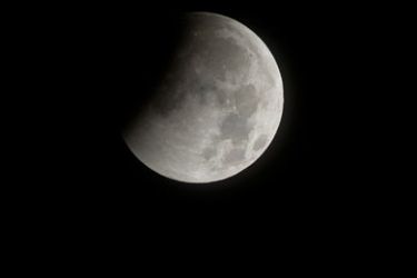 epa02503494 A handout photograph provided by the National Aeronautics and Space Administration (NASA) shows a total lunar eclipse beginning as the full moon is shadowed by the Earth on the arrival of the winter solstice, 21 December 2010, in Arlington, Virginia, USA.