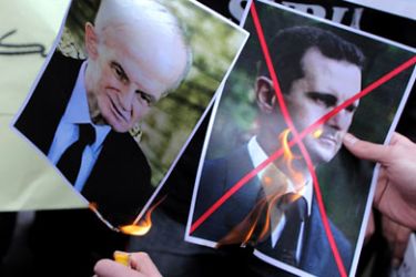 epa A file photograph dated 13 May 2011 shows Protestors burning pictures of Syrian President Bashar al-Assad (R) and his father Hafez during a demonstration after Friday