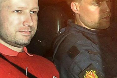 Bomb and terror suspect Anders Behring Breivik (red top) leaves the courthouse in a police car in Oslo on July 25, 2011, after the hearing to decide his further detention. Breivik will be held in solitary confinement for the first four weeks, with a ban on all communication with the outside world in a bid to aid a police investigation into his acts.