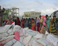 نساء نازحات يصطفن للحصول على موادغذائية توزعها منظمة إغاثة سودانية (الجزيرة)