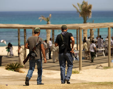 مقاتلان من الثوار في جولة مع مواطنيهم لمنتجع ريغاتا بضواحي طرابلس (الفرنسية)