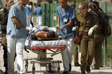 f_An injured Israeli soldier is wheeled into Beersheva’s Soroka hospital on August 18, 2011. Gunmen raked a bus with gunfire and blasted two other vehicles in a spate of attacks