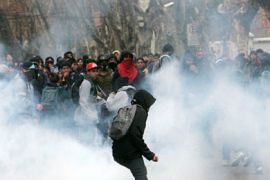 R_Students are besieged by tear gas during a rally to demand changes in the public state education system in Santiago August 4, 2011.