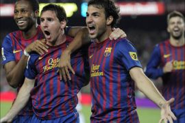 Barcelona's Argentinian forward Lionel Messi (C) is congratulated by his teammates Barcelona's midfielder Cesc Fabregas (R) and Barcelona's Malian midfielder Seydou Keita (L) after scoring during the second leg of the Spanish Supercup football match FC Barcelona vs Real Madrid CF on August 17, 2011 at the Camp Nou stadium in Barcelona. Barcelona won the Spanish Supercup 3-2. AFP PHOTO/ JOSEP LAGO