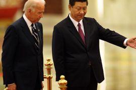 Chinese Vice President Xi Jinping (R) gestures to US Vice President Joe Biden (L) after listening to national anthems during a welcome ceremony in the Great Hall of the People in Beijing on August 18, 2011