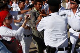 A protester against Egypt's former President Hosni Mubarak is stopped by police officers during clashes with pro-Mubarak supporters outside the police academy where his trial will take place, in Cairo August 3, 2011. Mubarak was shown wheeled into a cage in court in Cairo on Wednesday with his two sons and other defendants to stand trial for his role in the killing of protesters, state television images showed.