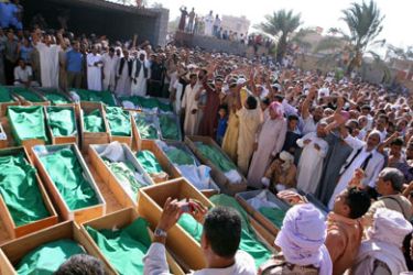 Libyan mourners gather around coffins during a mass funeral in the village of Majer, 10 kms (six miles) south of Zliten, on August 9, 2011 as Libyan authorities accused NATO of a "massacre" of 85 villagers in air strikes in support of rebels.