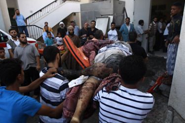 f_Palestinians carry one of six bodies into the morgue in the al-Najar Hospital in the southern Gaza Strip town of Rafah, on August 18, 2011