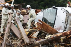 An aerial view shows firefighters searching among collapsed houses following a landslide caused by strong tropical storm Talas in Tanabe, Wakayama prefecture, in western Japan September 4, 2011. Tropical depression Talas, downgraded earlier from tropical storm, pounded western Japan with heavy rain at the weekend, leaving 17 people dead and a few dozens missing, public broadcaster NHK said on Sunday.