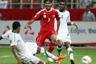 afp-Omani player Hussien al-Hadari( C) vies for the ball against Saudi's Abdullah al-Dossari (L) and Hamed al-Muntashari (4)