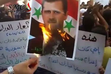 An image grab from footage uploaded on YouTube shows a protester burning a picture of Syrian President Bashar al-Assad during an anti-regime student demonstration in Damascus on September 19, 2011.