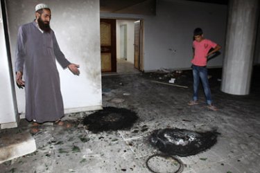 r_Palestinians look at burnt tires inside a mosque in the West Bank village of Qusra, near Nablus September 5, 2011. Jewish settlers set fire to part of the mosque in the occupied West Bank on Monday,