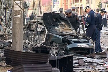 A video grab released by News Team agency shows police officers looking at a damaged car at the site of the twin explosions in Makhachkala, the capital of Russia's North Caucasus region of Dagestan, on September 22, 2011. The explosions within metres (yards) of each other rocked Makhachkala after midnight today killing a police officer and injuring dozens of others as well as civilians, officials said. AFP PHOTO / NEWS TEAM