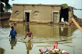 Pakistani flood-affected villagers wade through floodwaters in Jhudo district on September 16, 2011. The United Nations said that it was stepping up aid to Pakistan, where monsoon floods have killed 270 people, affected over 5.5 million others and destroyed 1.1 million homes. AFP PHOTO/Asif HASSAN