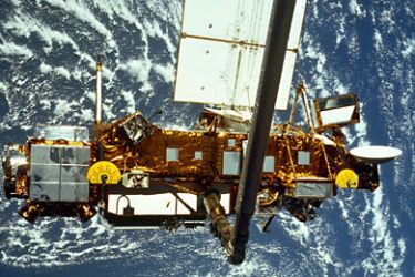 f_an STS-48 on board photo of the Upper Atmosphere Research Satellite (UARS) in the grasp of the RMS (Remote Manipulator System) during deployment. The bus size UARS, decommissioned on December 14, 2005,