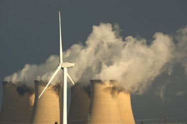 SELBY, ENGLAND - AUGUST 24: Recently installed wind turbines generate electricty in the shadow of Drax, Europe's biggest coal fired power station, on August 24, 2010 in Selby, England. The Rusholme wind farm will create 24 Mega Watts when fully operational in comparison to Drax which creates 3,960 Mega Watts. (Photo by Christopher Furlong/Getty Images)