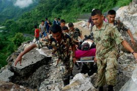Members of the Nepalese army carry an injured man at an area near a landslide after a 6.9 magnitude earthquake hit Nepal, in Dhankuta District September 19, 2011. A total of 80 kilometres of road in the area was damaged in two sections of the stretch. Rescuers dug through mudslides on roads to isolated Himalayan villages on Monday in search of survivors after the earthquake killed 63 people in India, Nepal and the Chinese region of Tibet.
