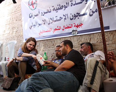 الألمانية فيرا ماخث وإلى جانبها الأميركي جو كاثرن مع فلسطينيين في خيمة الإضراب بغزة (الجزيرة نت)