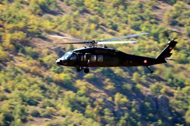 A Turkish army helicopter hovers above the base of the Cukurca brigade on October 21