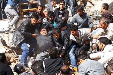 Turkish men carry an injured man as they take part in a rescue operation to salvage people from a collapsed building after an earthquake in Van, in eastern Turkey, on October 23, 2011. More than 1,000 people were likely to have been killed in an earthquake as powerful as the one that struck on 23 October in eastern Turkey, experts from the Kandilli Observatory and Earthquake