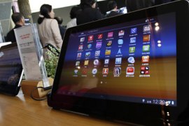 r_Visitors walk past Samsung Electronics' Galaxy Tab 10.1 tablets on display at a registration desk at the headquarters of South Korean mobile carrier KT in Seoul October 13, 2011
