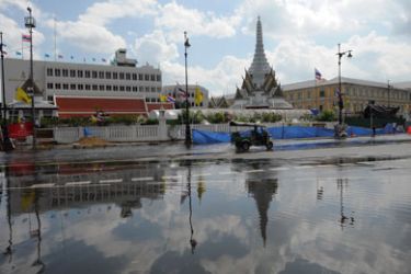 Motorists travel through floodwaters near the Grand Palace as floodwaters close in on the historic centre of Bangkok on October 30, 2011. Floods engulfing parts of the Thai capital should start to recede soon, the prime minister said after barriers along Bangkok's swollen main river prevented a disastrous overflow.