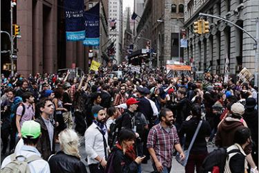 Members of the Occupy Wall Street movement march down Wall Street during a protest march through the financial district of New York October 14, 2011. Officials in New York City Friday postponed a planned clean-up of the downtown Manhattan park where anti-Wall Street protesters set up camp a month ago, averting what many feared could have been a showdown with authorities. REUTERS/Lucas Jackson (UNITED STATES - Tags: BUSINESS CIVIL UNREST POLITICS)