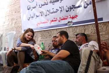 المتضامنة فيرا ماخث (يسار) وإلى جانبها المتضامن الأمريكي جو كاثرن يتناولان الملح والماء في خيمة الإضراب عن الطعام بجوار مقر لجنة الصليب الأحمر بغزة