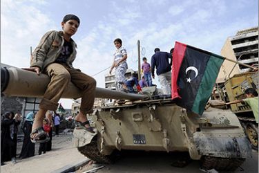 Libyan children play on a tank as weapons and other items belonging to the former regime are displayed in Misrata on October 23, 2011. Libya's new leaders will declare liberation in the wake of Moamer Kadhafi's death, paving the way for the formation of an interim government followed by the first free vote in 42 years. AFP PHOTO/PHILIPPE DESMAZES