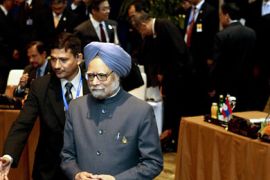 India's Prime Minister Manmohan Singh is guided to his seat at the start of the ASEAN and India Summit in Nusa Dua, Bali, November 19, 2011. REUTERS/Stephen Morrison/Pool (INDONESIA - Tags: POLITICS)