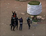 قوات الأمن المركزي تحيط بأحد المتظاهرين في ميدان التحرير (الجزيرة)