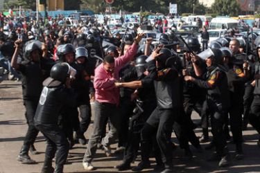 Egyptian riot policemen scuffle with a protester at Cairo's landmark Tahrir Square on November 19, 2011 following clashes after police dispersed a sit-in by people wounded during this year's uprising.