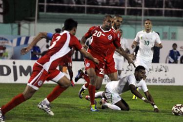 ف-Algeria's Hilal Soudani (R) falls as he vies for the ball with Tunisia's Aymen Abdenour (20) during their
