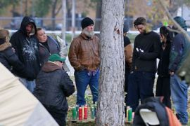 People gather around a makeshift candle memorial in the spot where a man died in his tent overnight during the Occupy Salt Lake City Protest November 11, 2011 in Salt Lake City, Utah. Authorities believe the man died from a combonation of carbon dioxide poisoning from a heater in the tent and drug use