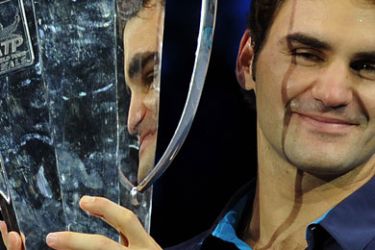 ف-Roger Federer of Switzerland poses with the ATP World Tour Finals tennis tournament singles trophy