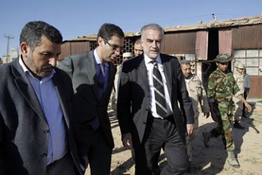 Chief Prosecutor of the International Criminal Court (ICC) Luis Moreno-Ocampo (C) visits the site of a mass grave at the Al-Yarmuk military base in Tripoli on November 23, 2011.