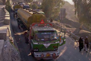 Drivers walk past trucks parked along the highway, including those carrying supplies to NATO forces in Afghanistan, after Pakistan's Torkham border was shut down to traffic November 26, 2011.