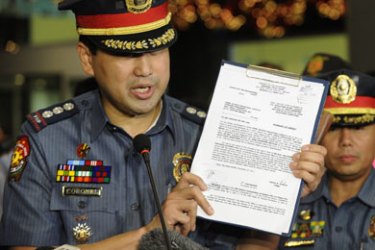 Senior Superintendent Joel Coronel shows the warrant of arrest a police team served on former Philippine President Gloria Arroyo at St. Luke's Medical Center in Manila on November 18, 2011. Philippine police arrested ex-president Gloria Arroyo at her hospital bed on November 18 on charges of conspiring with a feared warlord to rig an election, an offence that could lead to life in jail.