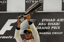 ف-McLaren Mercedes' British driver Lewis Hamilton celebrates winning on the podium at the Yas Marina