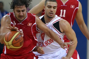 ف-Tunisia's Marouane Laghnej (L) advances challenging with Lebanon's Ali Mahmoud (C) during the basketball match