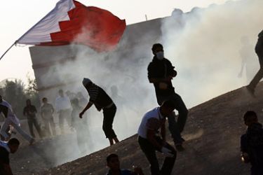 Bahraini anti-government protesters run for cover from tear gas fired by riot police in the Shiite village of Abu Saiba, west of Manama, on December 16, 2011 after clashes broke out during the funeral of Ali al-Qassab, a demonstrator killed the day before