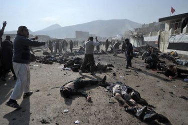 Afghan men cry as they try remove the bodies and help wounded people after explosions during a religious ceremony in the centre of Kabul on December 6, 2011