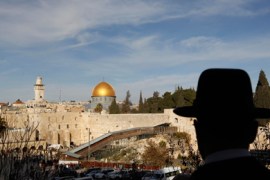 An ultra-Orthodox Jewish man stands at a view-point overlooking a wooden ramp (C) leading up from Judaism's Western Wall to the sacred compound known to Muslims as the Noble Sanctuary and to Jews as Temple Mount, where the al-Aqsa mosque and the Dome of the Rock shrine stand, in Jerusalem's Old City December 12, 2011.