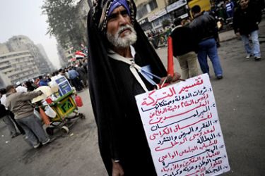 : An Egyptian man walks with a sign listing the problems Egypt has "inherited" from ousted president Hosni Mubarak, during a demonstration in Cairo's Tahrir Square on December 30, 2011. A major clampdown on human rights groups in Egypt has called into question the ruling military's pledges of reform, drawing a torrent of criticism of its handling of the transition from Hosni Mubarak