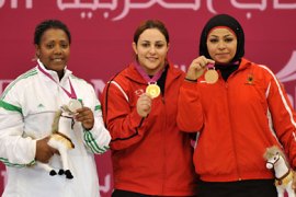Egypt's Nahla Mohamed (C) shows her gold medal with silver medalist, Algeria's Touria Kendouci (L) and bronze medalist, Jordan's Rola Ali (R) on the podium during the medal ceremony of women's weightlifting +75kg Clean and Jerk at Al-Dana indoor hall of Khalifa complex during the pan-Arab Games 2011 in the Qatari capital Doha on December 15, 2011. AFP