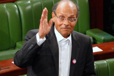 Former doctor and human rights campaigner Moncef Marzouki waves to the media at the constituent assembly in Tunis December 12, 2011.