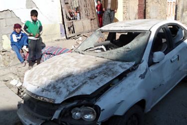 Iraqis inspect a destroyed car following a blast in the central city of Baquba, 60 kms (40 miles) north of Baghdad, on January 4, 2012. Bomb and grenade attacks north of Baghdad killed three people -- two children and a policeman -- and wounded 17 other people, officials said. AFP PHOTO/STR