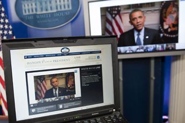 US President Barack Obama participates in an interview with YouTube and Google from the Roosevelt Room of the White House in Washington, DC, January 30, 2012, as seen on a laptop in the Brady Press Briefing Room. The interview, held through a Google+ Hangout, marks the first