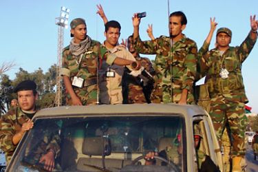 عرض عسكري للثوار بعد رجوعهم من الجبهة في بنغازي،والتعليق كالتالي: قوات المجلس الانتقالي قادرة على مواجهة المليشيات المسلحة ( الجزيرة نت)