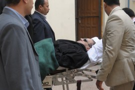 Ousted Egyptian president Hosni Mubarak is wheeled on a stretcher into court for his murder trial in Cairo on January 5, 2012.